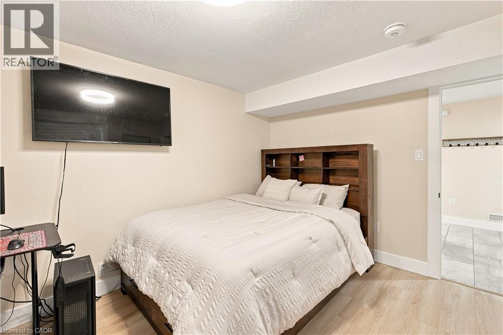Light wood-finish flooring with white baseboards and painted walls - 62 Corfield Drive, Kitchener, ON