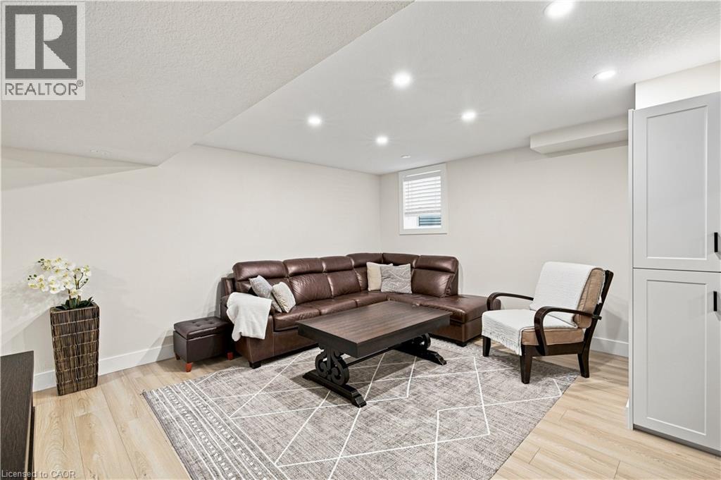 Recessed lighting illuminates the space, featuring light wood-finish flooring and white walls - 62 Corfield Drive, Kitchener, ON