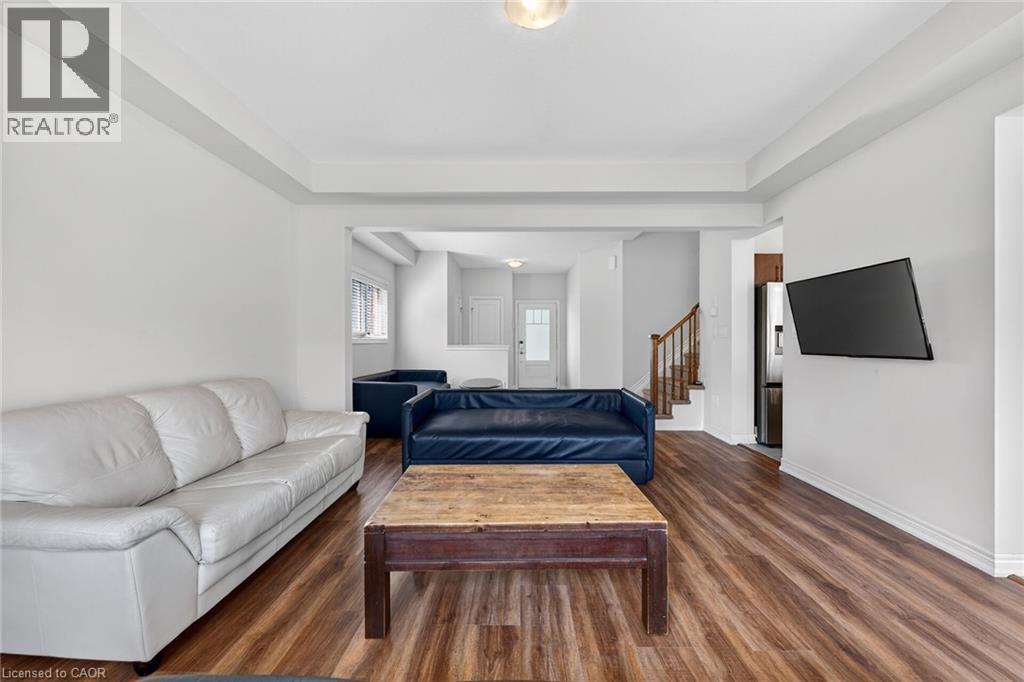 Spacious room featuring wood-finish flooring, white walls, and a recessed ceiling - 9 Winterberry Boulevard, Thorold, ON