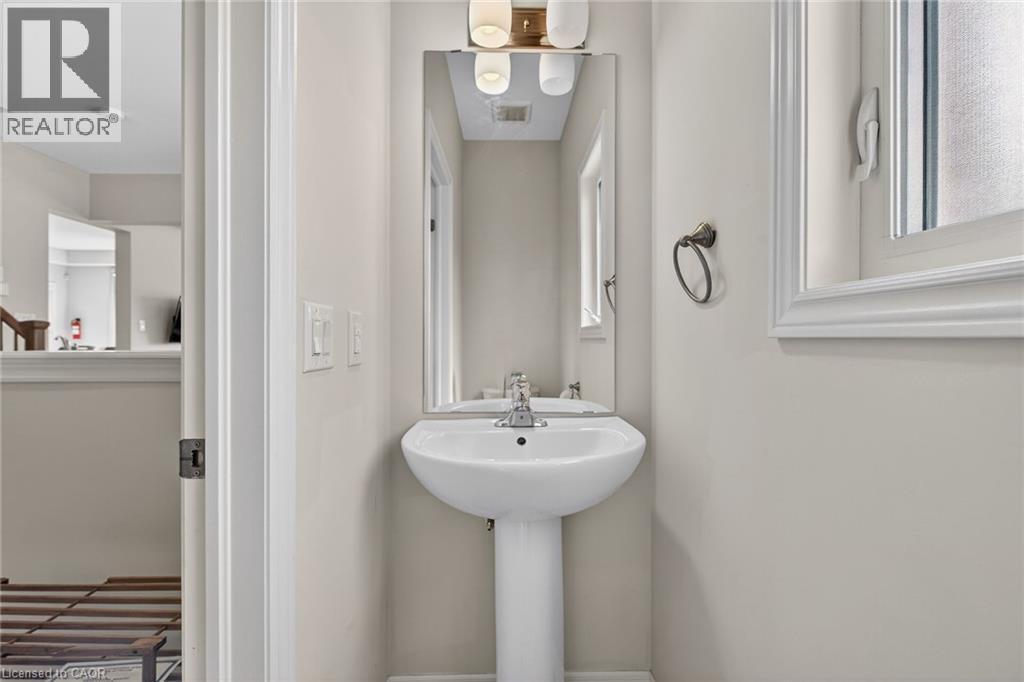 Pedestal sink with chrome fixtures and a rectangular mirror - 9 Winterberry Boulevard, Thorold, ON