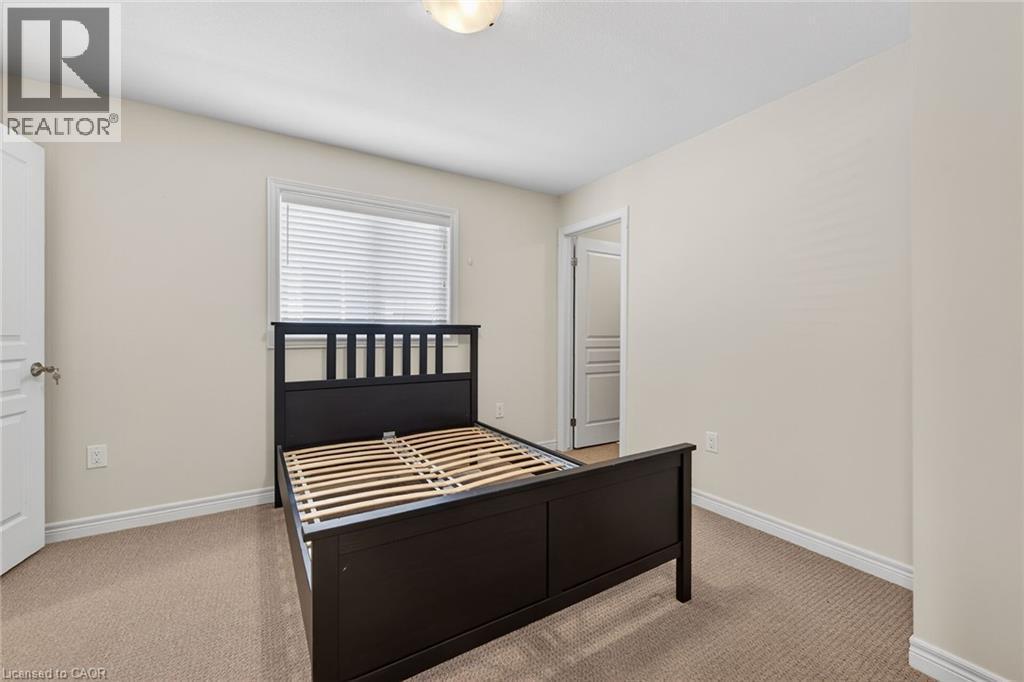 Neutral wall paint, textured carpet flooring, white trim, and a window with horizontal blinds - 9 Winterberry Boulevard, Thorold, ON