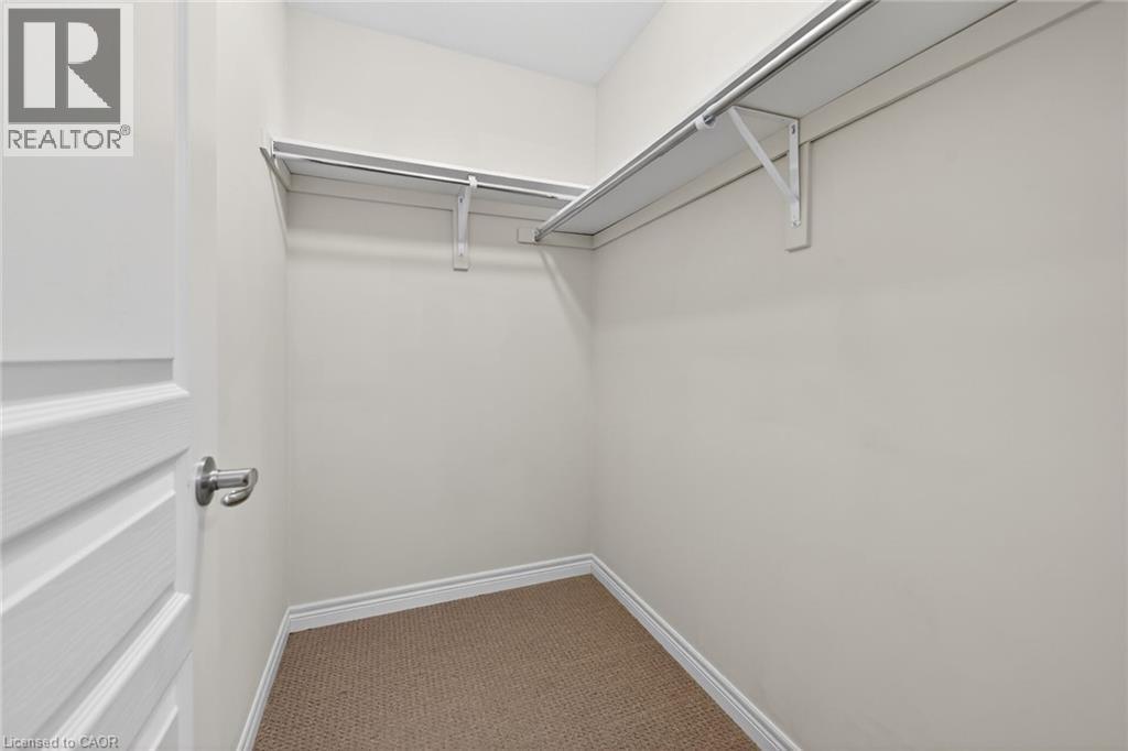 Closet featuring carpet flooring, built-in shelving, and hanging rods - 9 Winterberry Boulevard, Thorold, ON