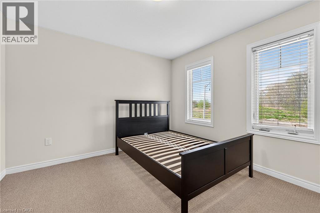 Neutral wall paint, carpet flooring, and two windows with blinds - 9 Winterberry Boulevard, Thorold, ON