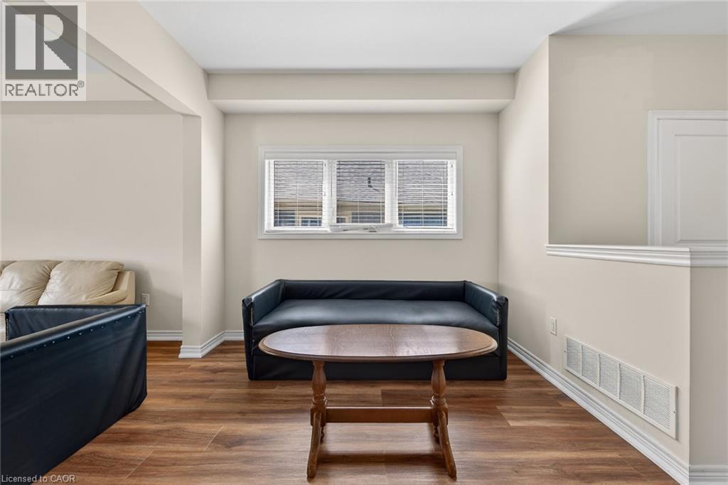 Wood-finish flooring with white baseboards, natural light from a window with blinds, and neutral painted walls - 9 Winterberry Boulevard, Thorold, ON