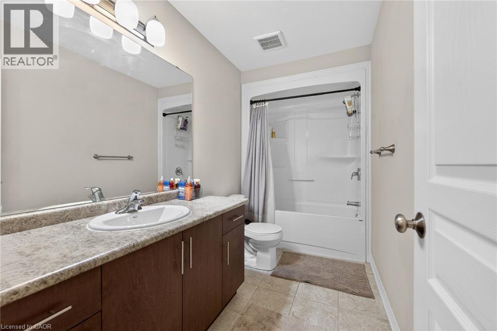 Vanity with an integrated sink, laminate countertop, and wood-finish cabinetry - 9 Winterberry Boulevard, Thorold, ON