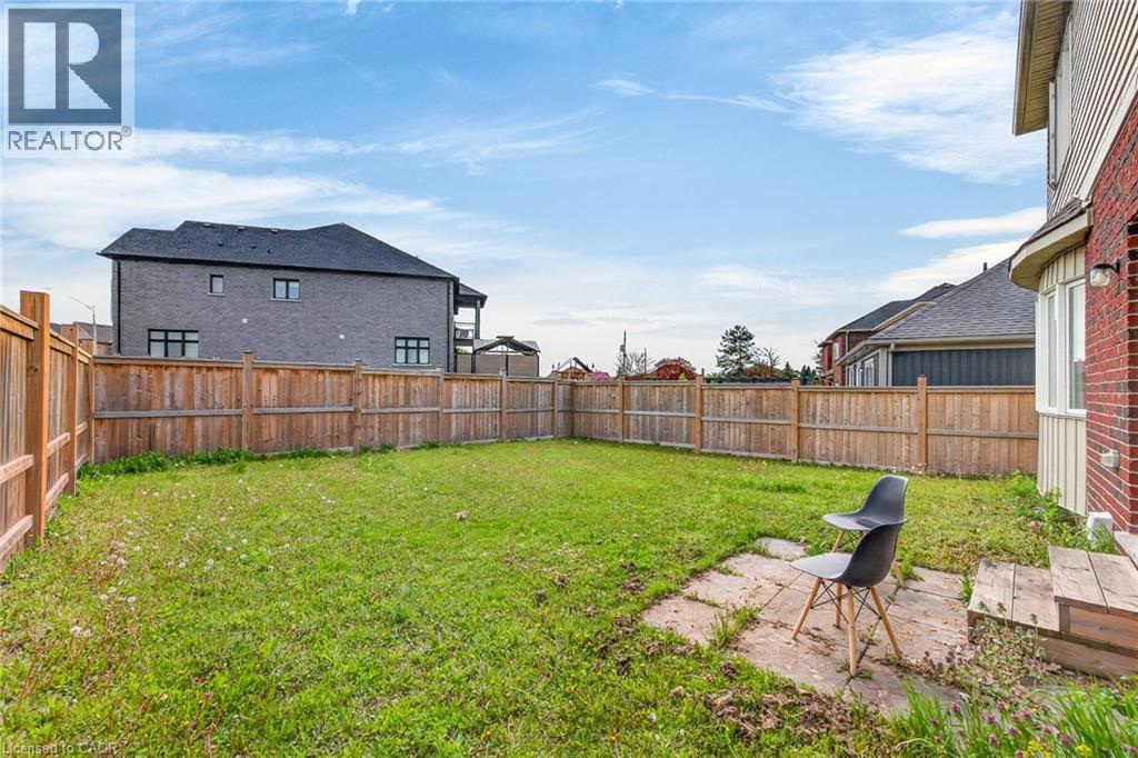 Expansive backyard with a wooden fence enclosure and a grass lawn - 9 Winterberry Boulevard, Thorold, ON