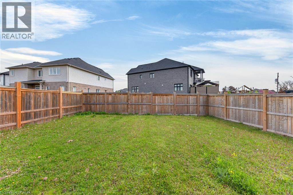 Expansive grassy yard area with a perimeter wood fence - 9 Winterberry Boulevard, Thorold, ON