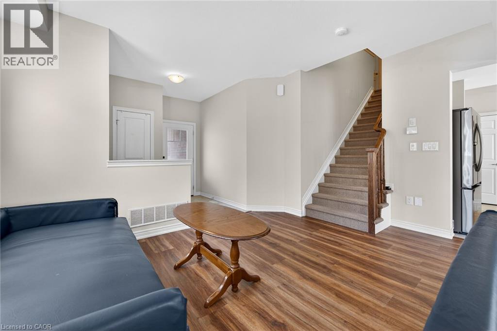 Wood-finish flooring throughout, with a carpeted staircase featuring wood railing - 9 Winterberry Boulevard, Thorold, ON