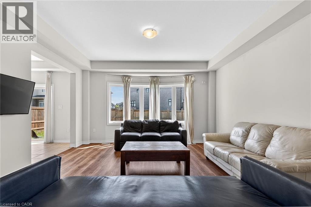 Wood-finish flooring throughout, featuring a bay window, recessed ceiling, and a flush mount ceiling light - 9 Winterberry Boulevard, Thorold, ON