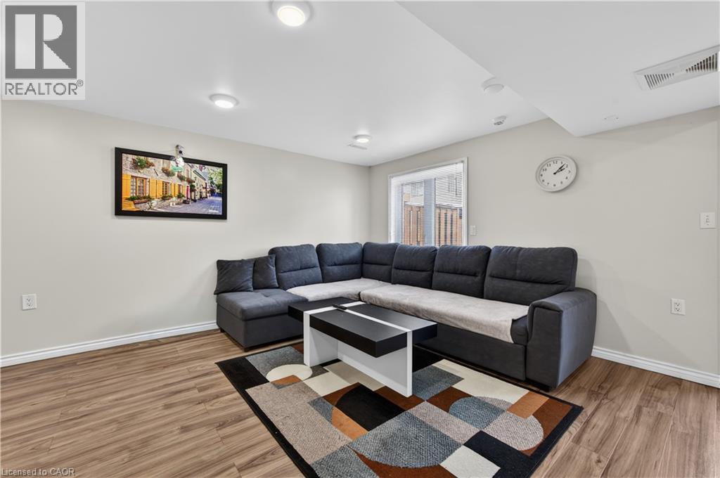Recessed lighting throughout, wood-finish flooring, light neutral wall paint, and a sliding glass door - 88 Highgate Drive, Hamilton, ON