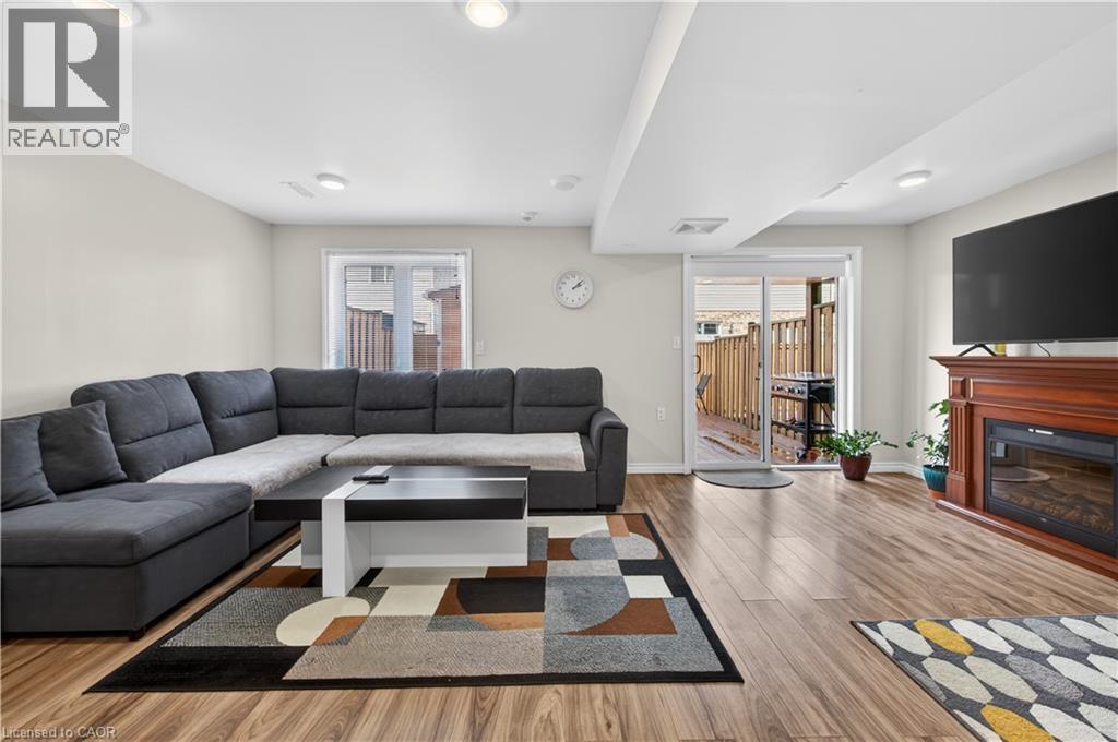 Recessed lighting, wood-finish flooring, sliding glass door, and a built-in fireplace with a wood mantle - 88 Highgate Drive, Hamilton, ON