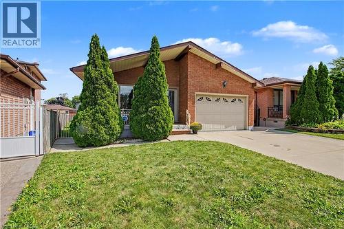 Brick exterior with an attached garage and concrete driveway - 14 Indian Crescent, Hamilton, ON 