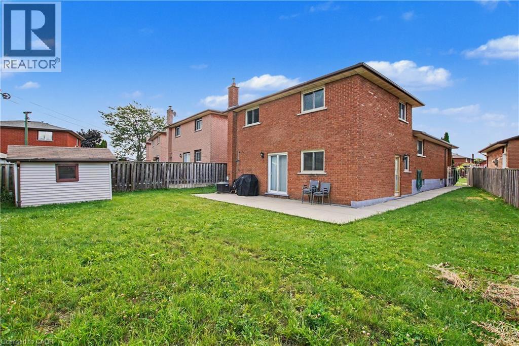 Expansive grass lawn with a storage shed and privacy fencing - 14 Indian Crescent, Hamilton, ON