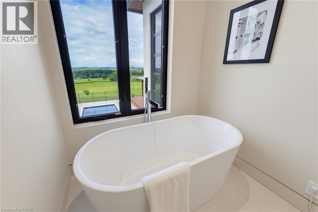 Luxurious freestanding soaking tub with elegant oval silhouette and clean white finish - 5709 Forth Line, Hillsburg, ON