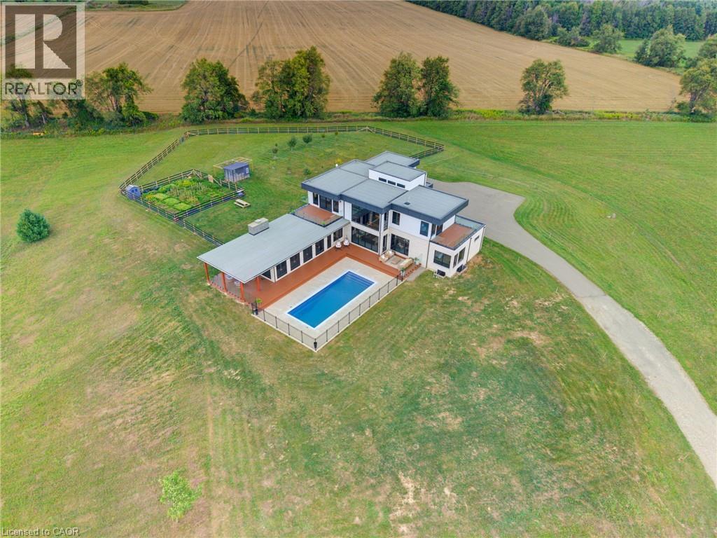 Contemporary architecture with multiple rooflines, an in-ground swimming pool, an expansive deck, a private driveway, and an enclosed garden area - 5709 Forth Line, Hillsburg, ON
