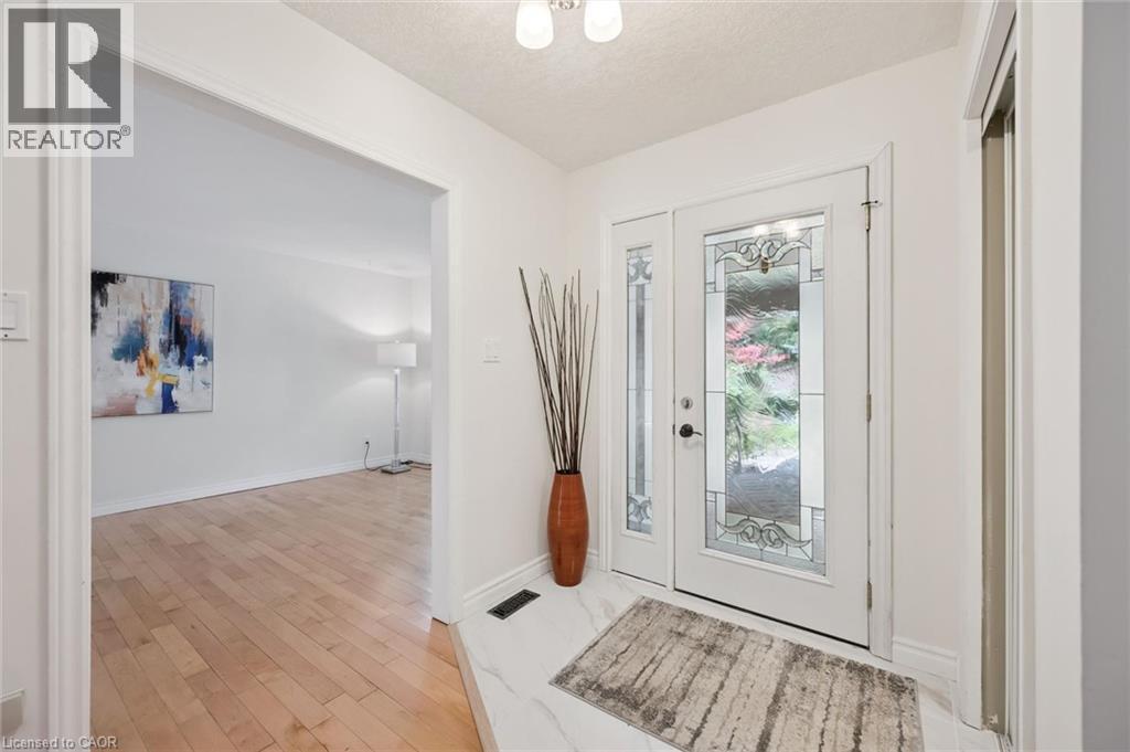 Entryway featuring a white door with decorative glass inserts, a white side panel with decorative glass, and a white ceiling light fixture - 345 Beechlawn Drive, Waterloo, ON