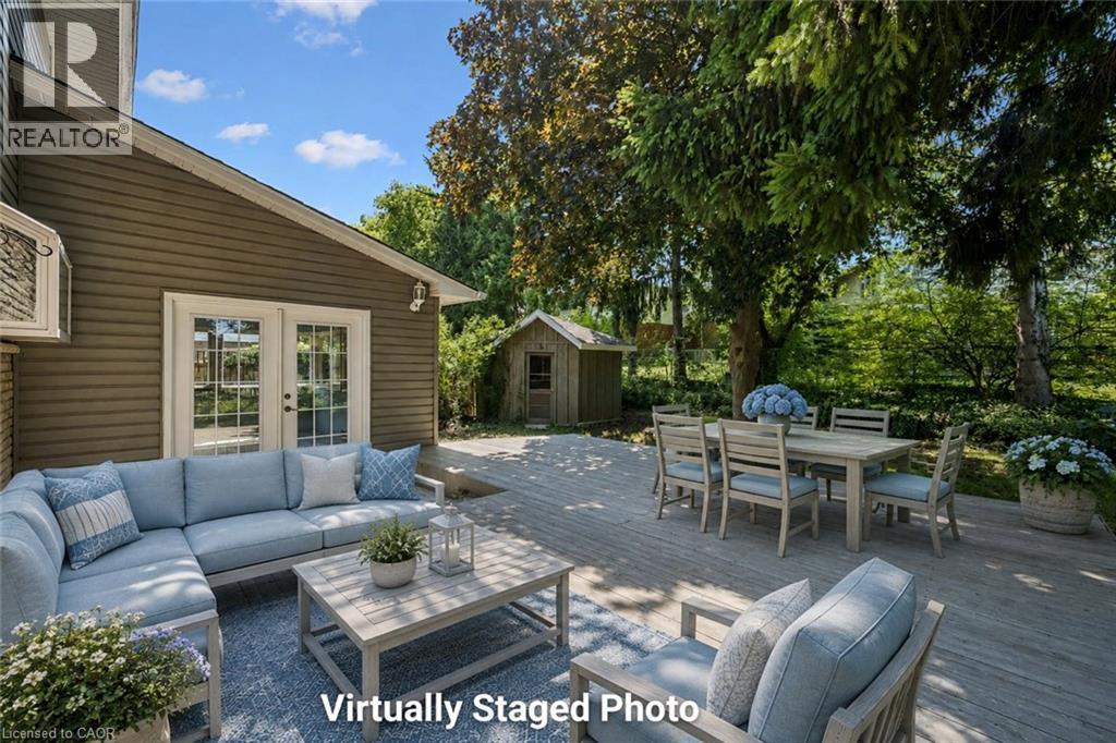 Expansive outdoor deck featuring wood-finish flooring, direct access via patio doors, and a detached shed - 345 Beechlawn Drive, Waterloo, ON