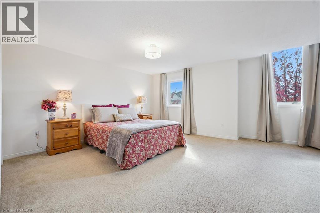 Spacious room with light-colored carpeting, multiple windows, and a ceiling-mounted light fixture - 151 Clairfields Drive Unit# 3, Guelph, ON