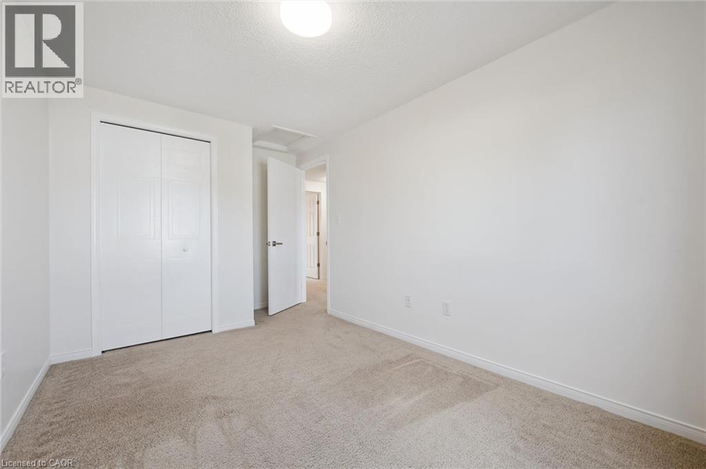 Neutral tone wall finishes, carpeting, flush mount ceiling light fixture, and bifold closet doors - 151 Clairfields Drive Unit# 3, Guelph, ON