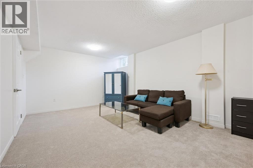 Expansive carpeted area with white walls, a single window, and a built-in overhead light fixture - 151 Clairfields Drive Unit# 3, Guelph, ON