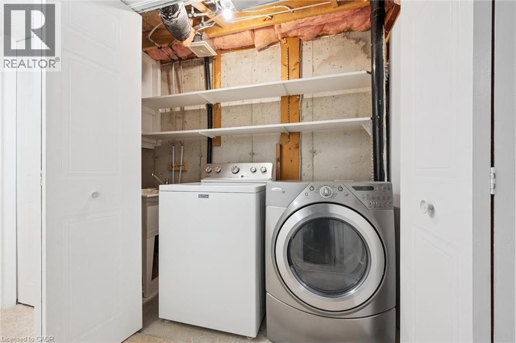 Laundry area with stacked shelving and a utility sink - 151 Clairfields Drive Unit# 3, Guelph, ON
