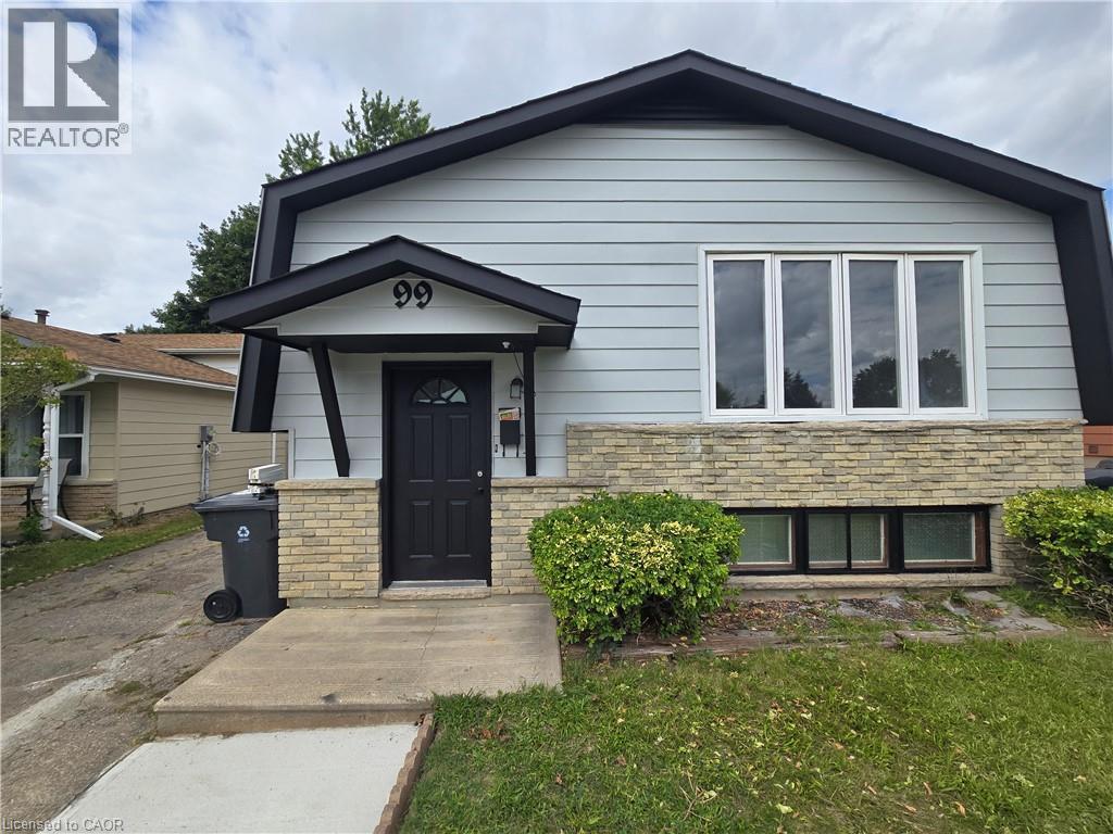 Modern brick and siding exterior featuring a peaked roofline, black-trimmed entry vestibule with paneled door, and expansive front-facing multi-pane window - 99 Cluthe Crescent, Kitchener, ON
