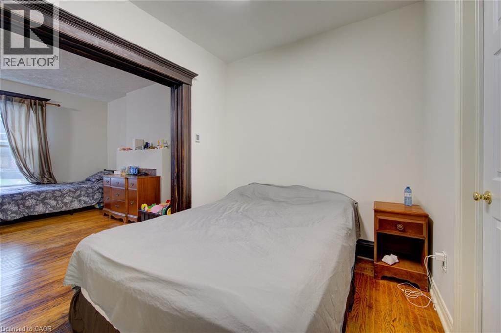 primary bedroom 1 with pocket doors to private livingroom, private 3 piece ensuite bath - 24 Hunt Street, Hamilton, ON