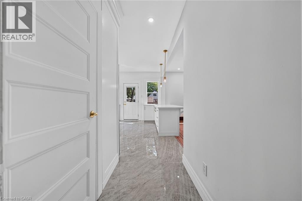Recessed lighting, panel door, gold-tone door hardware, and sleek flooring - 229 Park Row S, Hamilton, ON