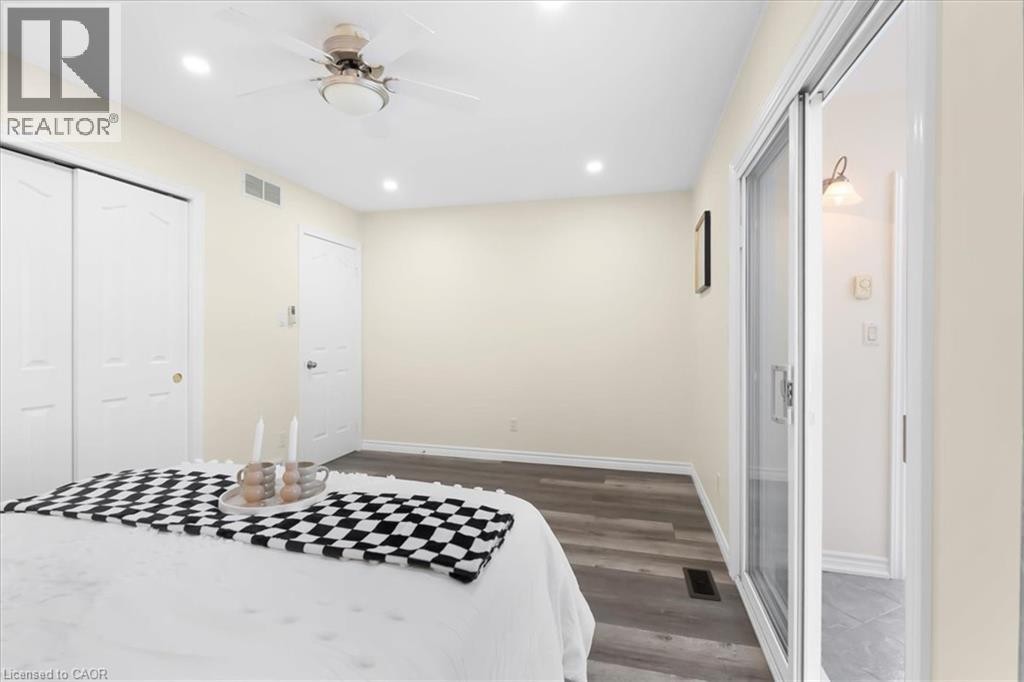 Wood-finish flooring, recessed lighting, ceiling fan, and sliding glass door - 150 Bankside Drive, Kitchener, ON