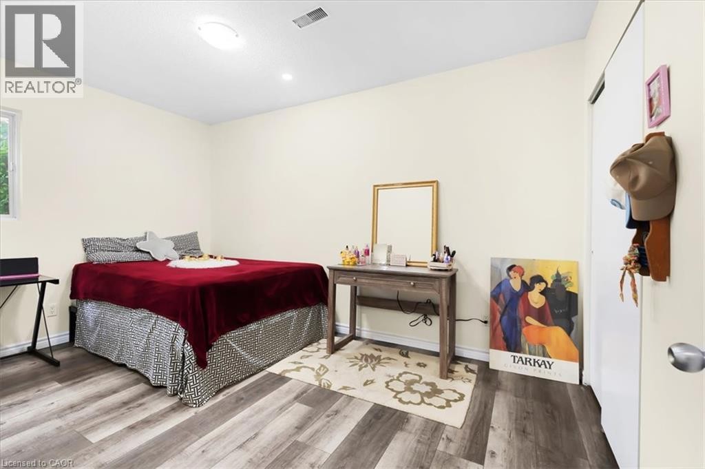 Wood-finish flooring, recessed lighting, ceiling-mounted light fixture, and a window providing natural illumination - 150 Bankside Drive, Kitchener, ON