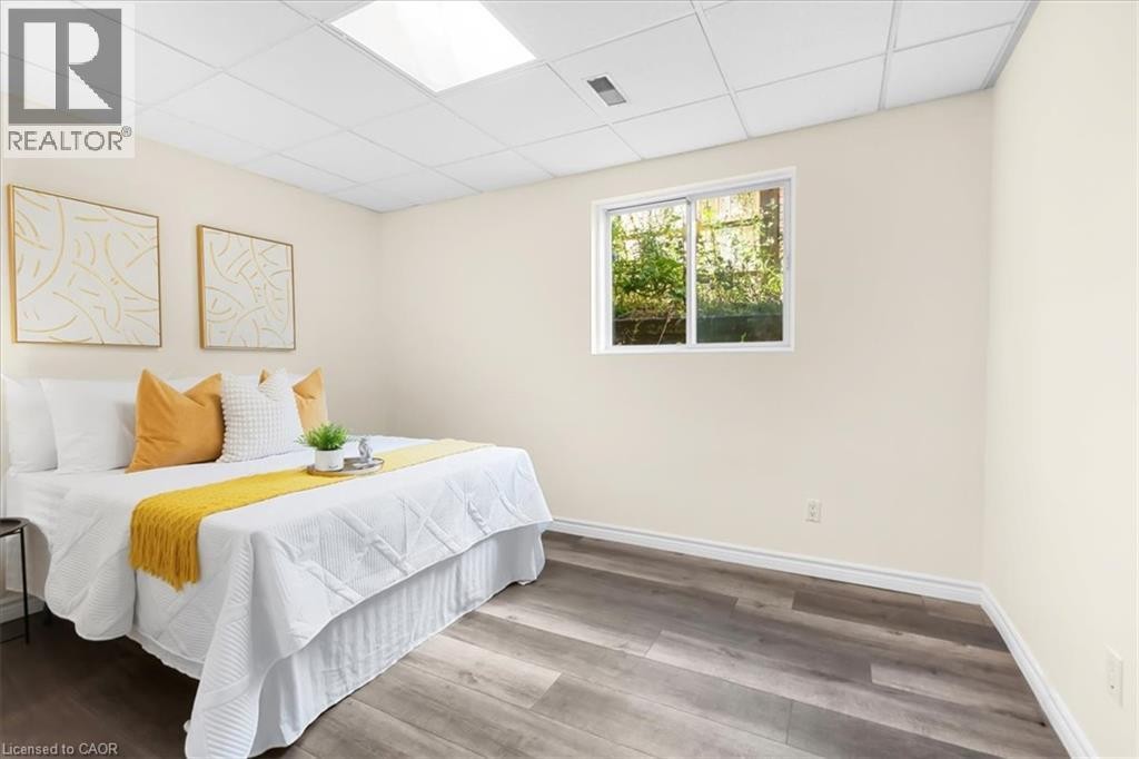 Wood-finish flooring, white trim, light-toned walls, and a window for natural light - 150 Bankside Drive, Kitchener, ON