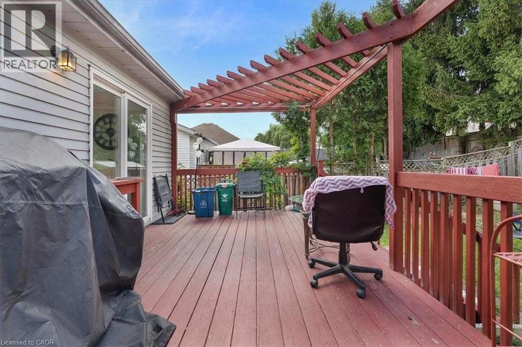 Expansive wooden deck featuring a pergola, sliding glass door access, and a durable wood railing - 150 Bankside Drive, Kitchener, ON
