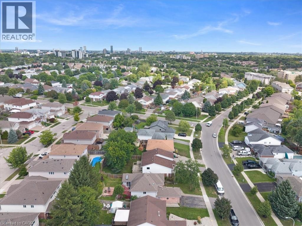 Residential neighborhood with tree-lined streets and a distant city skyline - 150 Bankside Drive, Kitchener, ON