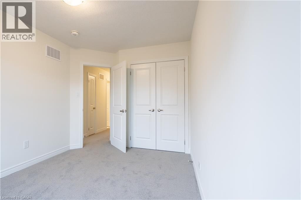 Soft neutral wall color, carpet flooring, and a flush mount ceiling light - 23 Dryden Lane, Hamilton, ON