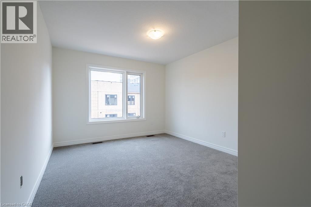 White walls with window trim, grey carpet flooring, and a ceiling-mounted light fixture - 23 Dryden Lane, Hamilton, ON