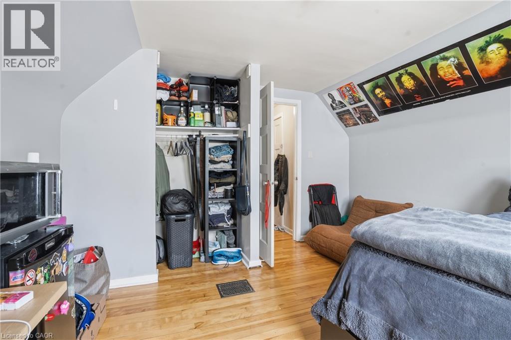 Hardwood-style flooring throughout this room, featuring light gray painted walls and a sloped ceiling - 139 Dalewood Avenue, Hamilton, ON