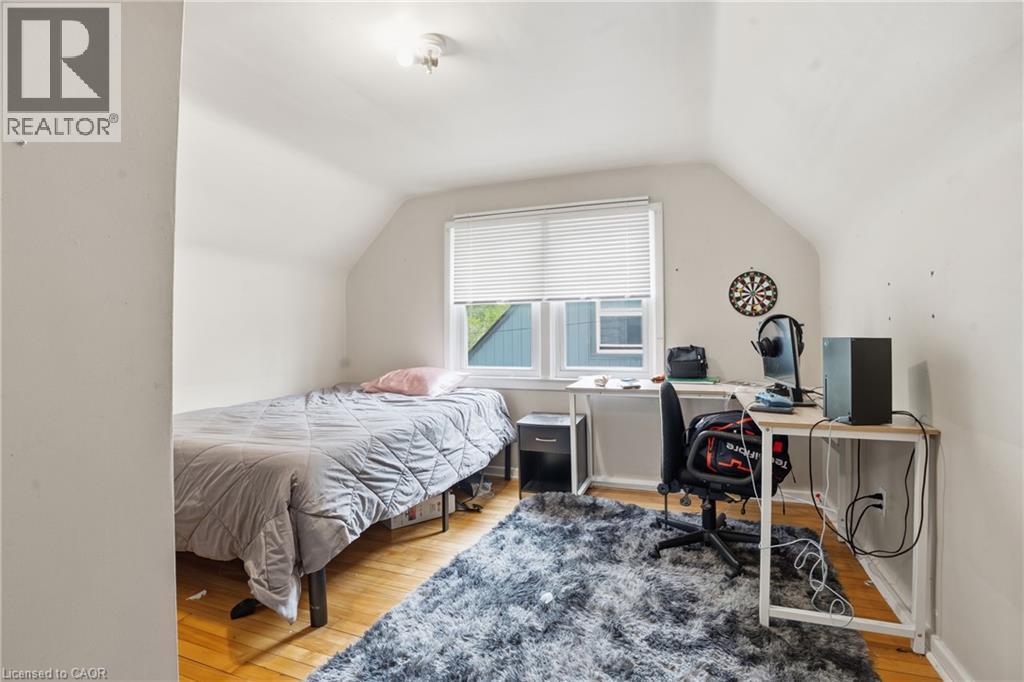 Room featuring wood-finish flooring, white walls, and an angled ceiling line - 139 Dalewood Avenue, Hamilton, ON