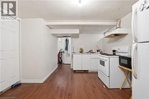 Kitchen space featuring wood-finish flooring, white cabinetry, a white electric range, and a white refrigerator - 139 Dalewood Avenue, Hamilton, ON 