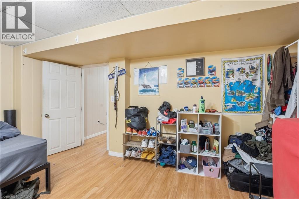 Room featuring wood-finish flooring, drop ceiling, and a paneled interior door - 139 Dalewood Avenue, Hamilton, ON