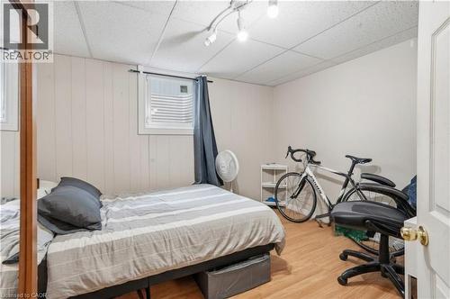 Room featuring wood-finish flooring, white paneled walls, and a drop ceiling with track lighting - 139 Dalewood Avenue, Hamilton, ON 