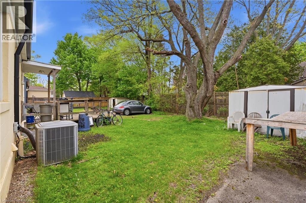 Expansive green lawn with mature trees, a covered patio, and a storage shed - 139 Dalewood Avenue, Hamilton, ON