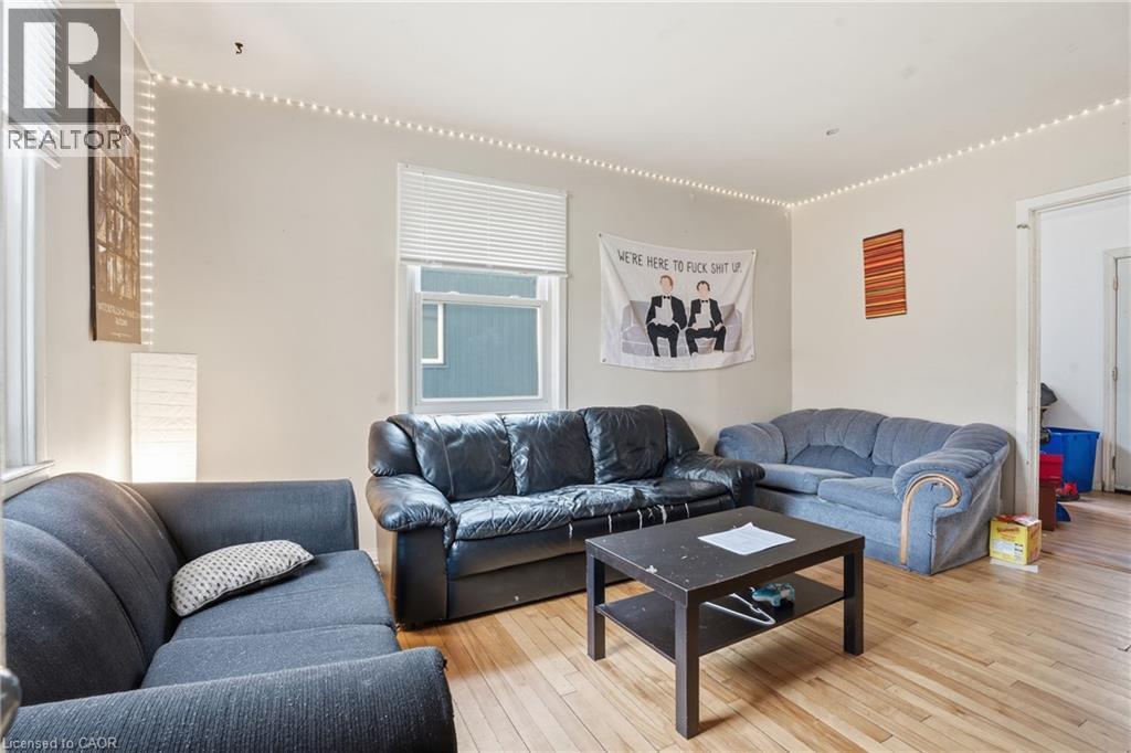 Living space featuring hardwood flooring, multiple windows with blinds, and light-toned walls - 139 Dalewood Avenue, Hamilton, ON