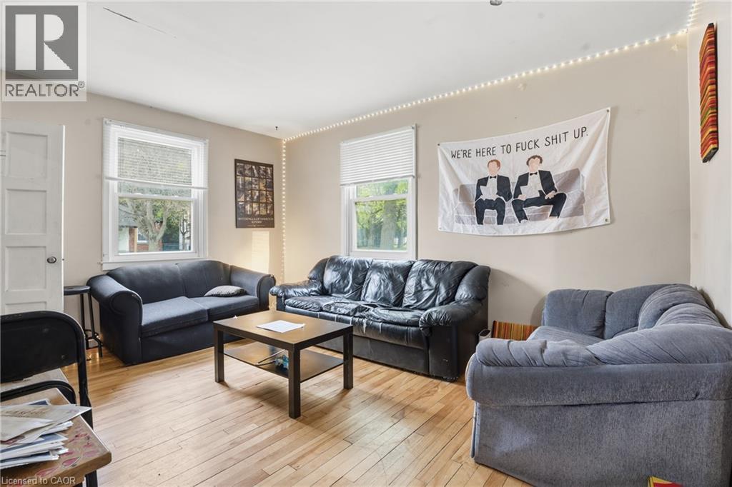 Living area featuring wood-finish flooring, light-colored walls, and multiple windows with blinds - 139 Dalewood Avenue, Hamilton, ON