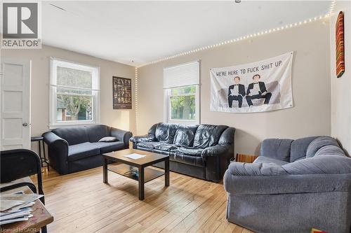 Living area featuring wood-finish flooring, light-colored walls, and multiple windows with blinds - 139 Dalewood Avenue, Hamilton, ON 
