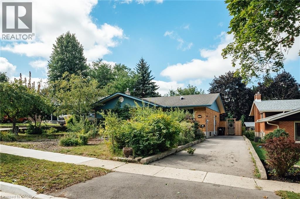 Brick exterior featuring a gabled roofline and an asphalt driveway - 229 Winfield Avenue, Waterloo, ON