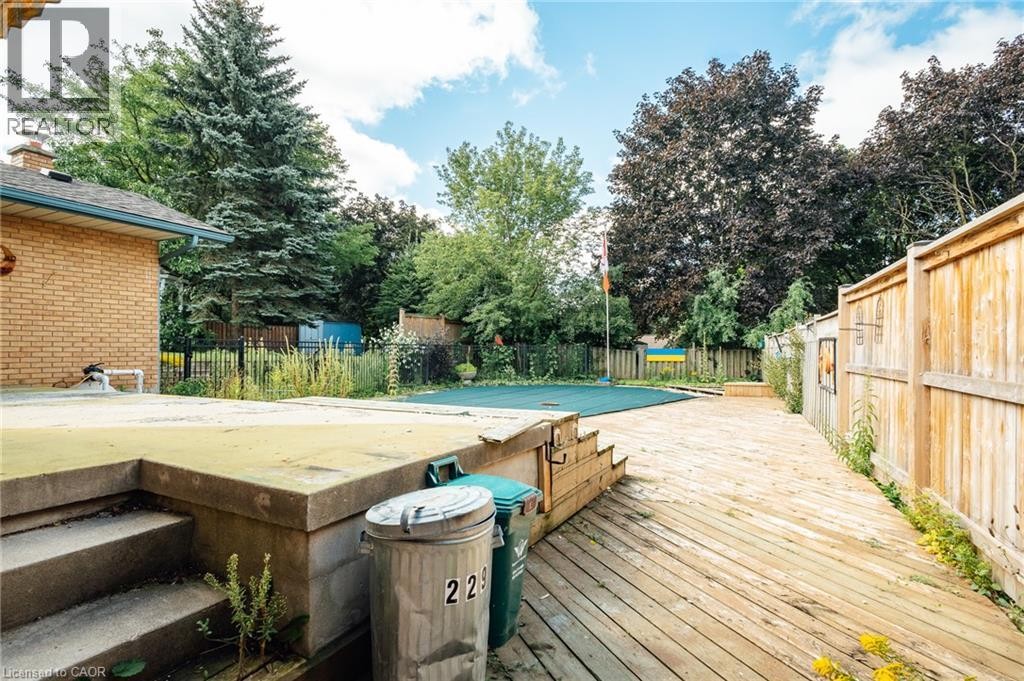 Backyard featuring a wooden deck, a concrete patio, and a privacy fence - 229 Winfield Avenue, Waterloo, ON