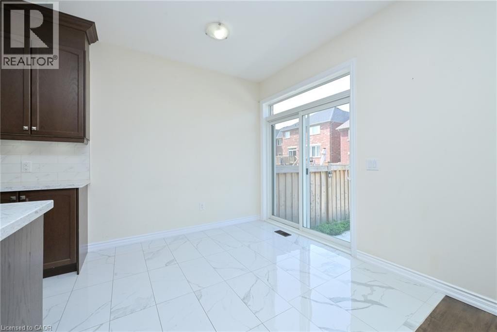 White tile flooring, sliding glass door, dark wood-finish cabinetry, white countertop, and white subway tile backsplash - 64 Maple Cider Street, Caledon, ON