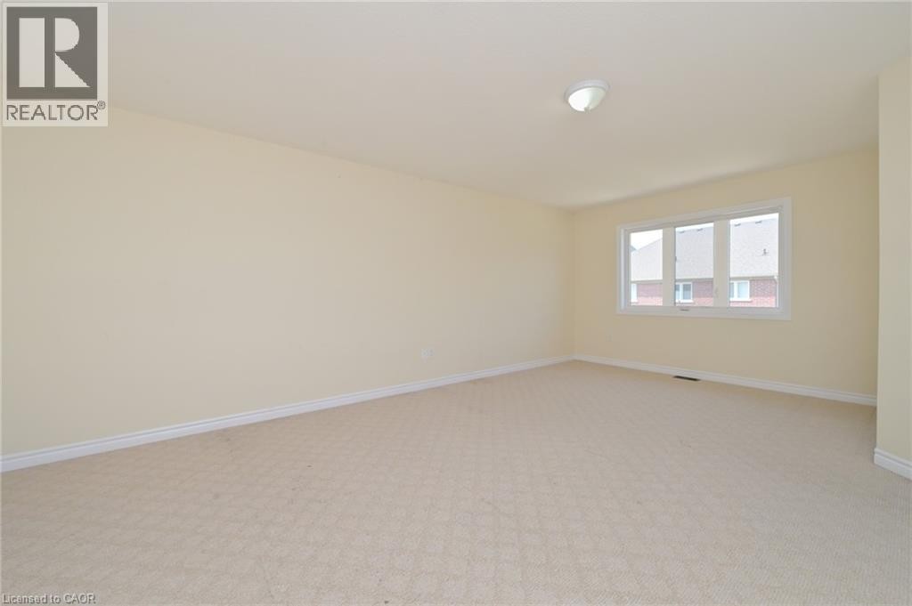 Carpeted flooring, neutral wall tones, triple window unit, and ceiling-mounted light fixture - 64 Maple Cider Street, Caledon, ON