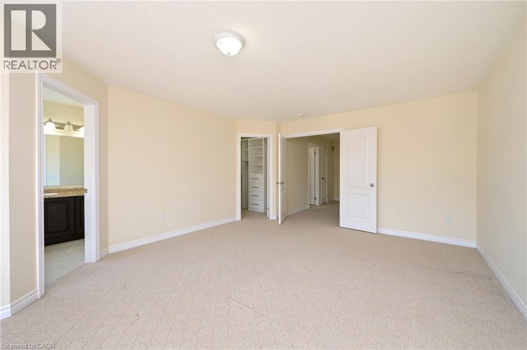 Expansive room featuring neutral-toned carpet, light-colored walls, and multiple doorways - 64 Maple Cider Street, Caledon, ON
