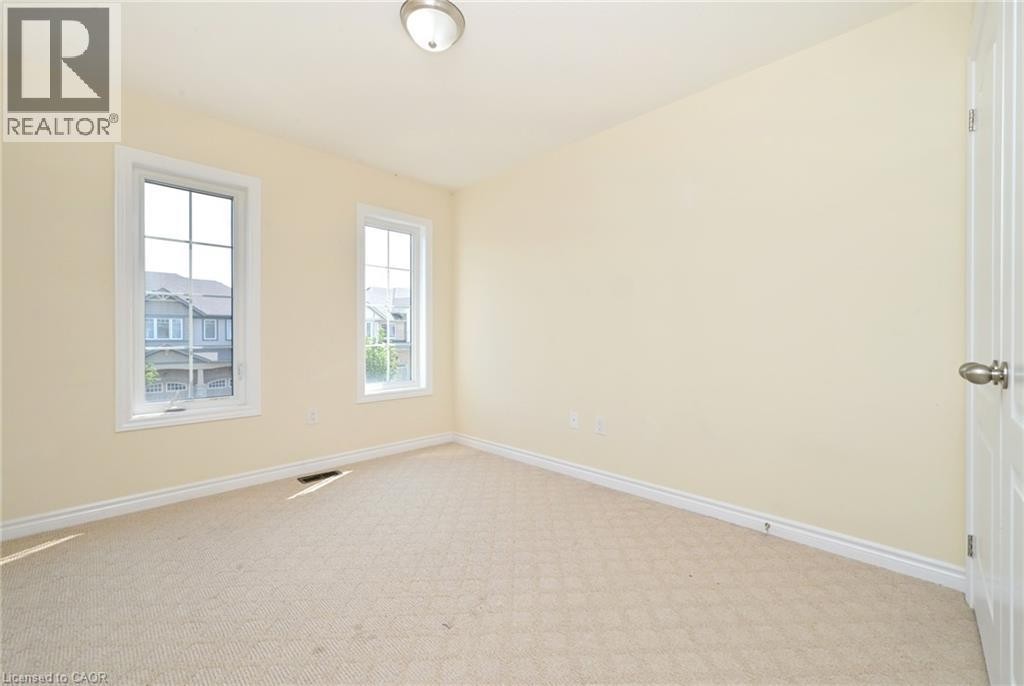 Recessed lighting, light-toned carpeting, and two paneled windows with white trim - 64 Maple Cider Street, Caledon, ON